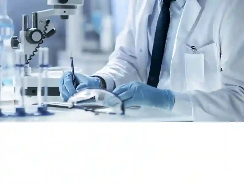 Kutató a laborban mikroszkóp mellett, jegyzetel – tanulmányok az Acala vízszűrőkről